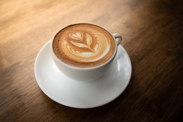 istock Coffee latte art in a cup on wood table 1005735790