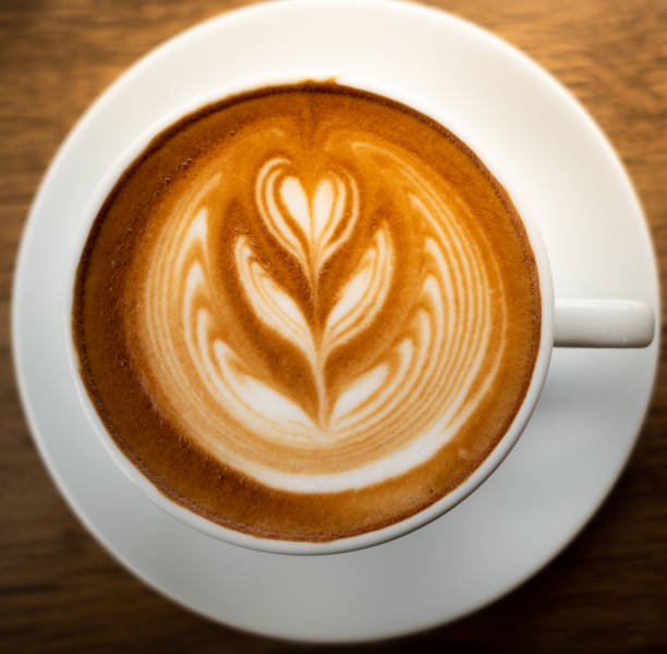 istock Coffee latte art in a cup on wood table 1005735798