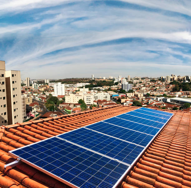 photovoltaic power plant on the roof of a residential building on sunny day - solar panels house imagens e fotografias de stock