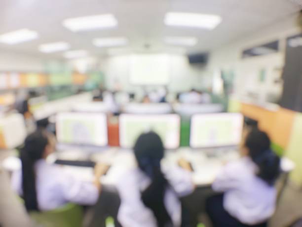 istock Blurred image of group of students are learning and sitting at desk using computer lap together in classroom for study and workshop in computers room at secondary school. education technology concept. 1005763502