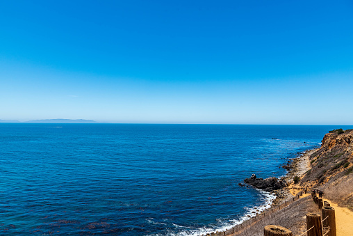Path to beach with cliff and deep blue ocean