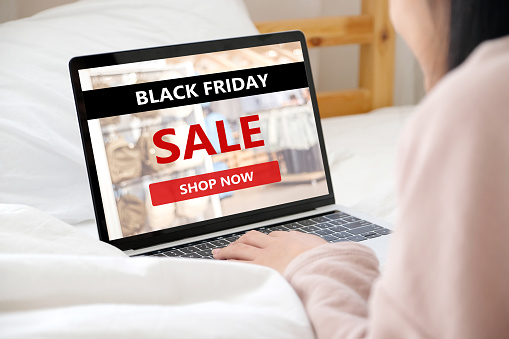 Woman hands typing laptop computer with black friday sale web banner on screen background, Online shopping sale, business and technology