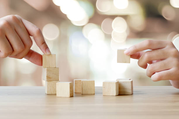 istock Hands holding blank wooden cubes on table over blur abstract bokeh light background, mock up, template, banner with copy space for text 1005771550