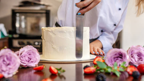 シェフの菓子はケーキを料理、新鮮な花を飾ります。背景イメージです。 - cake women confectioner photography ストックフォトと画像