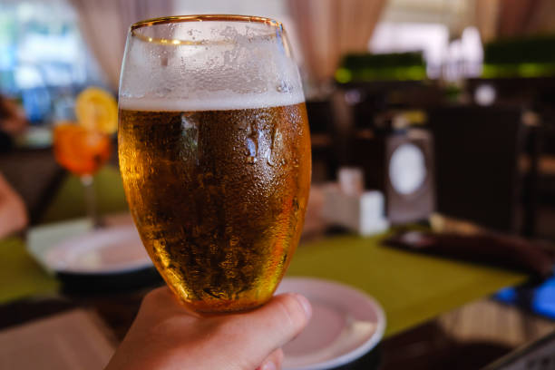 istock Beer in hand, cafe alcohol bar, restaurant cafe interior 1005798390