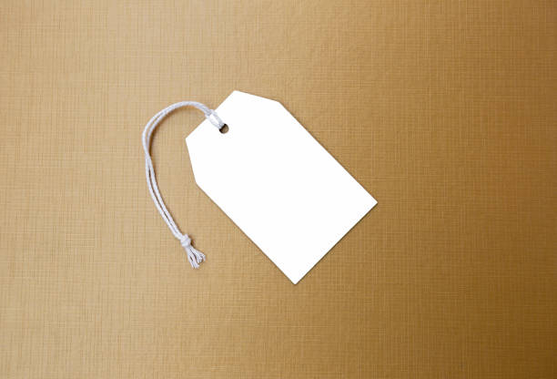 istock Blank white paper price tag on gold texture background 1005800848