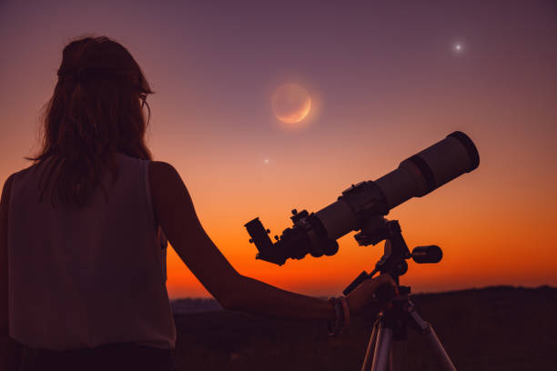 istock Girl looking at lunar eclipse through a telescope. My astronomy work. 1005803556