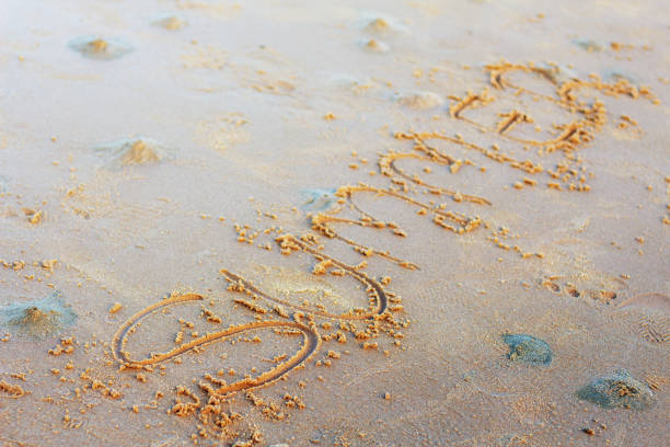 istock Wording of summer on sand. 1005805900