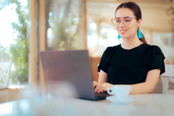 istock Freelance Woman Working Online Typing on Laptop in a Restaurant 1005809202