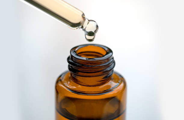 istock Essential oils with water drops in to the bottle on white background. 1005812404