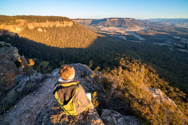 istock Male relaxing on a rock after bushwalk with spectacular views 1005824510