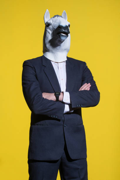 istock man with horse mask on yellow background 1005837086