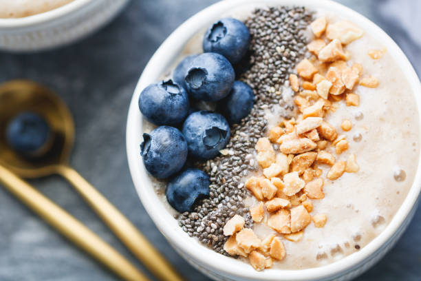 istock Banana dessert with chia seeds, fresh blueberry and nuts over grey table. 1005840060