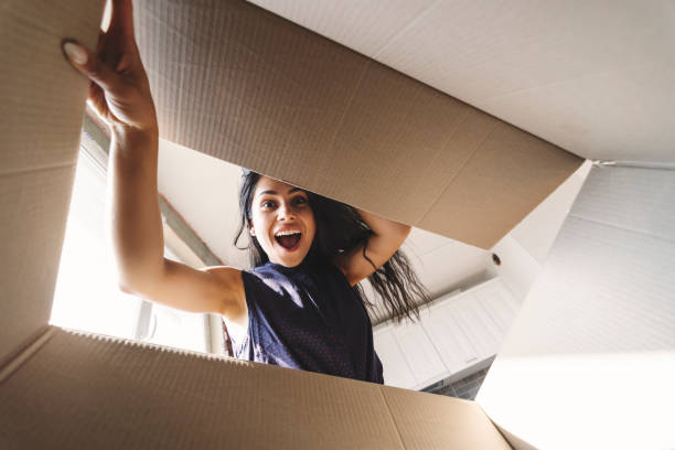 Smiling woman opening a carton box Pretty young happy woman opening a carton box box stock pictures, royalty-free photos & images