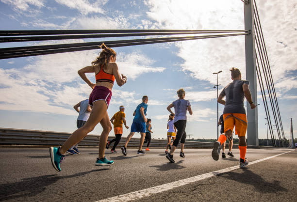 istock Below view of marathon runners from the back during a race on the bridge. 1005857812