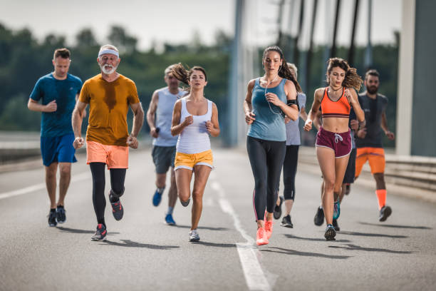 istock Large group of mix-aged marathon runners on a road. 1005860190