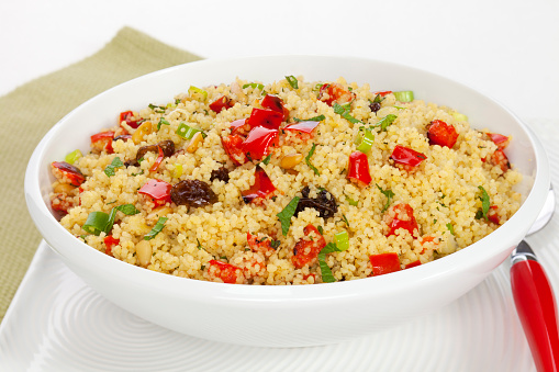 Couscous salad, with roasted red peppers, raisins, pine nuts, green onion and mint. Shallow DOF, focus on centre.
