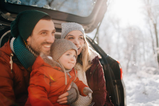 Family on a winter road trip Portrait of a young family getting ready for a winter road trip kids winter coat stock pictures, royalty-free photos & images