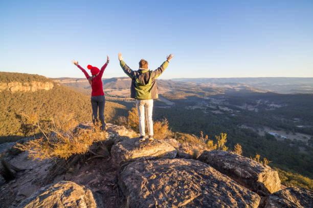 istock Two bush walkers on cliff top success achievement 1005864514