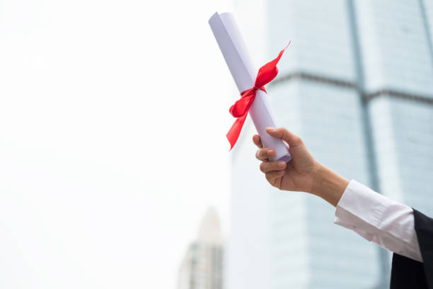 istock Hand holding Graduation certificate with raised up with success Bachelor degree 1005871242