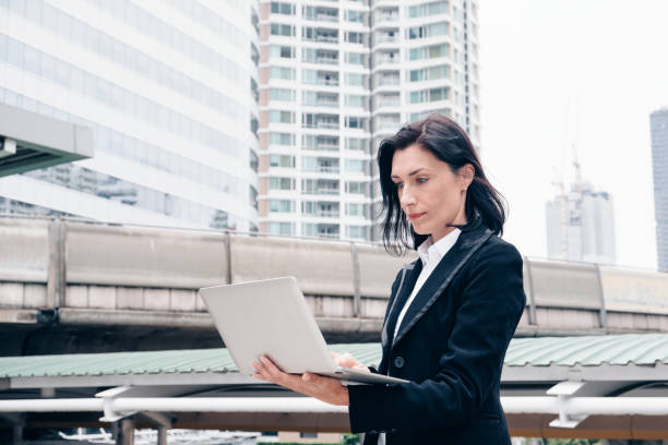 istock Smart businesswoman using laptop in the city 1005871464