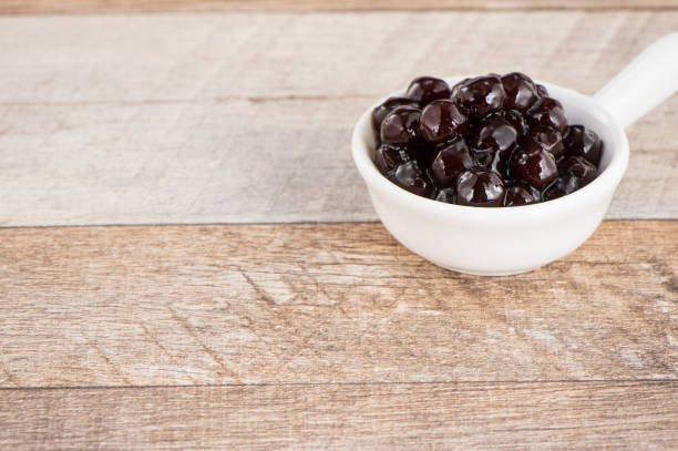 istock Tapioca Pearl , Bubble topping for tea or other beverage, in a cup, place on wooden table. Copy space 1005882032