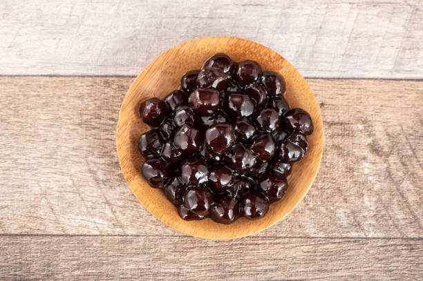 Tapioca Pearl , Bubble topping for tea or other beverage, in a cup, place on wooden table. Copy space