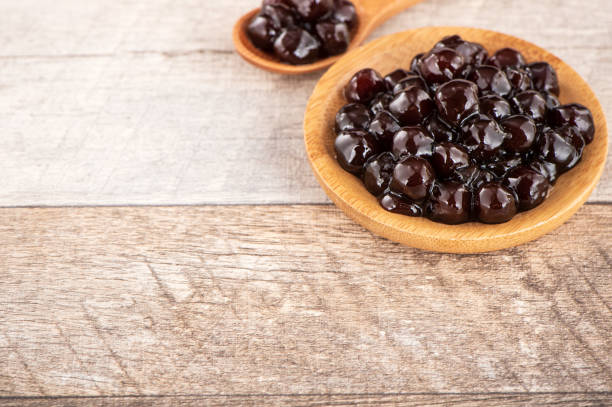 istock Tapioca Pearl , Bubble topping for tea or other beverage, in a cup, place on wooden table. Copy space 1005882150