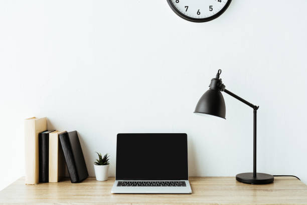 istock laptop with blank screen on work desk in front of white wall 1005882674