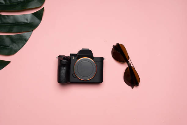 istock a sunglasses an a camera on a pink background 1005885114