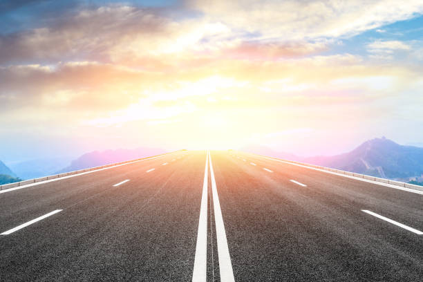 istock Asphalt road and great wall with mountains at sunset 1005886548