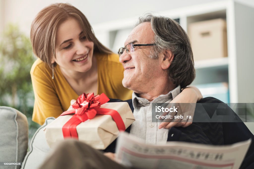 Young woman giving gift her father Father Stock Photo