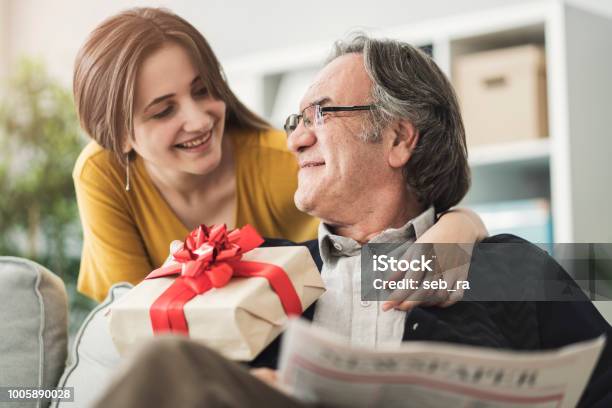 Foto de Jovem Mulher Dando De Presente Seu Pai e mais fotos de stock de Pai - Pai, Presente, Dia dos Pais