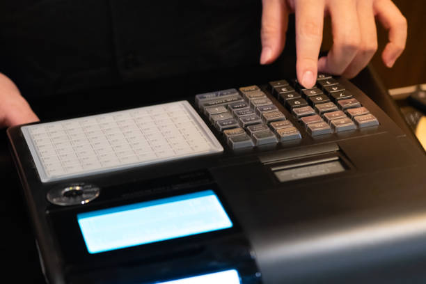 istock cash register installed on counter for accepting order from customer.sales man entering amount on electronic cash register in coffee shop and retail store.restaurant cashier typing on cash register. 1005893468