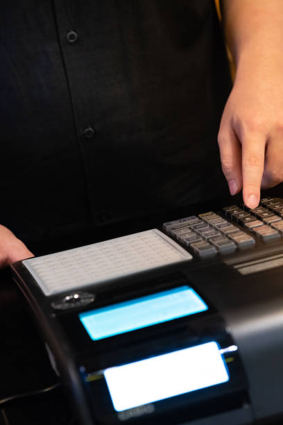 istock cash register installed on counter for accepting order from customer.sales man entering amount on electronic cash register in coffee shop and retail store.restaurant cashier typing on cash register. 1005893470