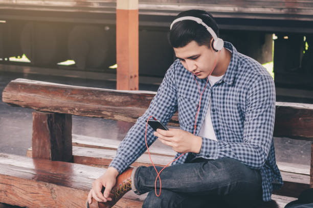 istock Hipster man listen music at train station. 1005893534
