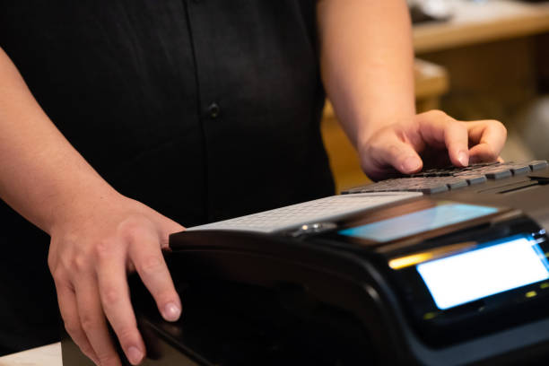 cash register installed on counter for accepting order from customer.sales man entering amount on electronic cash register in coffee shop and retail store.restaurant cashier typing on cash register. cash register installed on counter for accepting order from customer.sales man entering amount on electronic cash register in coffee shop and retail store.restaurant cashier typing on cash register. asian cashier stock pictures, royalty-free photos & images