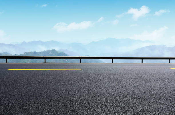 istock Asphalt road and great wall with mountains at dusk 1005894414