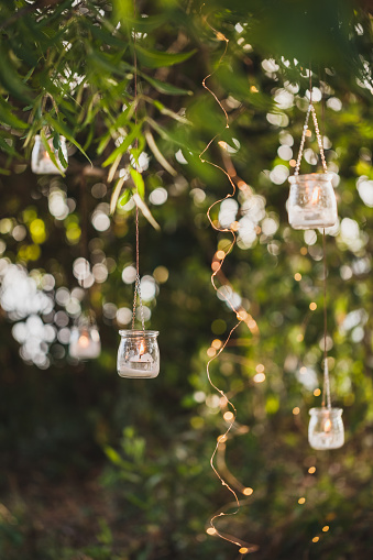 Night wedding ceremony with a lot of vintage lamps and candles on big tree