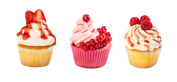 Set of cupcakes with raspberry, strawberry and redcurrant berries isolated on white background.