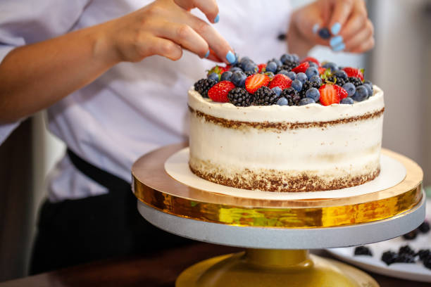 istock Girl chef cooks confectioner, decorates cake with forest berries. concept making without lactose cakes. Copy space, selective focus 1005897722