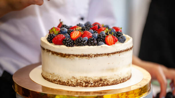 istock Girl chef cooks confectioner, decorates cake with forest berries. concept making without lactose cakes. Copy space, selective focus 1005897726