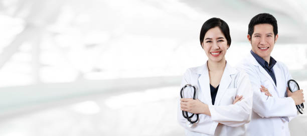 portrait of young attractive asian doctor team or physician group crossed arm holding stethoscope medical equipment, smile and look at camera in hospital feeling professional confident with copyspace. - healthcare and medicine nurse doctor general practitioner imagens e fotografias de stock
