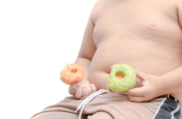 istock Obese fat boy is holding donut isolated 1005900574