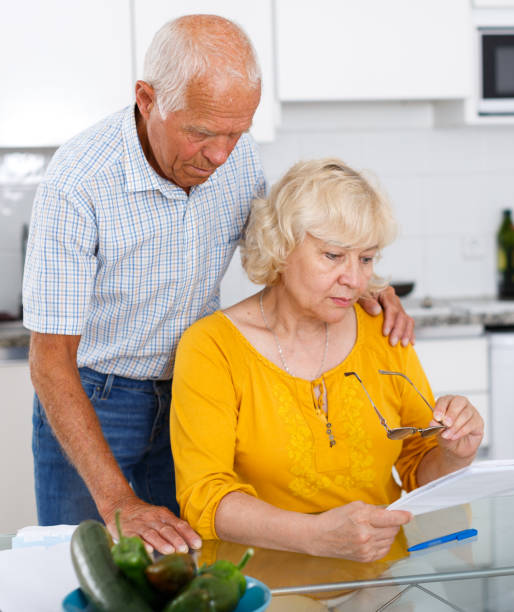 istock Mature couple at kitchen table filling up documents 1005918984