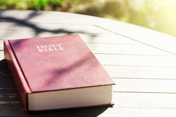 istock Holy Bible on outdoor table in dappled sunshine 1005922448
