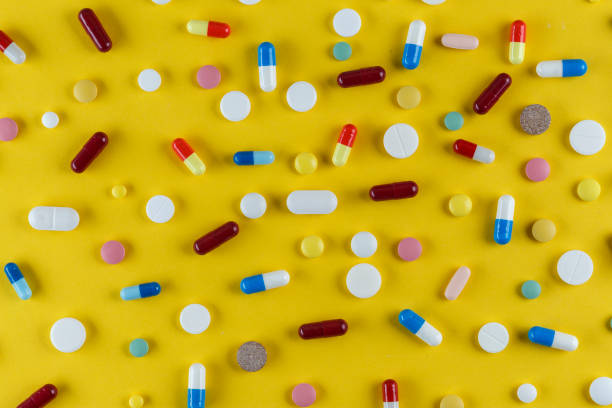 istock different pills and capsules scattered on a yellow background 1005926886