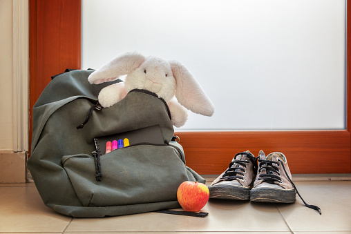 Zapatos y bolso de escuela con peluche, suministros y almuerzo photo