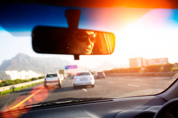 istock Woman's face is reflected in the rearview mirror during rush hour 1005934470