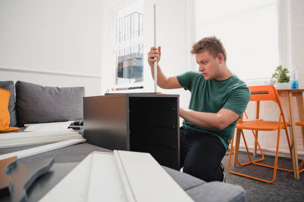istock University Student Putting Together Flat-Pack Furniture 1005939138